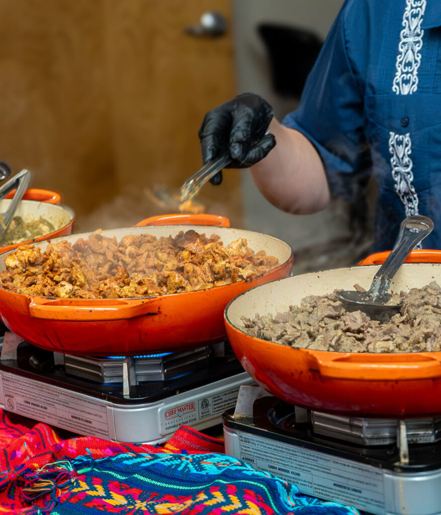 Cazuelita's team serving guests from a colorful buffet